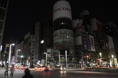 Una pareja solitaria cruza la calle en el barrio tokiota de Ginza.