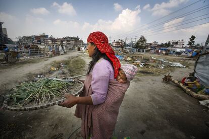 Una mujer observa el desalojo y demolición del último campamento para víctimas del terremoto de abril de 2015, donde residían cientos de personas en Katmandú (Nepal).