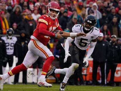 Kansas City Chiefs quarterback Patrick Mahomes (15) runs out of the pocket as Jacksonville Jaguars safety Andre Cisco (5) defends during the first half of an NFL divisional round playoff football game, Saturday, Jan. 21, 2023, in Kansas City, Mo.