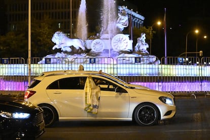 La timidez de la bandera que asoma de ese coche que pasa por la Fuente de Cibeles, lugar de reunión habitual en los triunfos madridistas, da una idea de cómo celebró el Real Madrid su trigésimo cuarto campeonato liguero. Pocos fueron los que se acercaron a adorar una diosa privada de multitudes, pero no de milagros futbolísticos. En una temporada partida por la pandemia, los blancos firmaron un regreso a la competición con diez victorias seguidas que revirtieron la desventaja respecto al FC Barcelona con la que se marcharon al parón. Dejando sola a la Cibeles, pero con título.