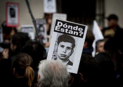 Activistas de la organización chilena de derechos humanos 'Personas detenidas y desaparecidas' muestran imágenes de desaparecidos durante la dictadura militar (1973-1990), mientras se reúnen frente al palacio presidencial de La Moneda, en Santiago.