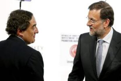 El presidente del Gobierno, Mariano Rajoy (d), conversa con el presidente de la CEOE, Juan Rosell, durante una conferencia sobre inversiones y oportunidades en Turquía que tiene lugar hoy en Madrid.