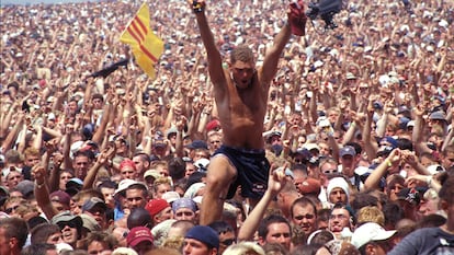 Un hombre se alza sobre la multitud que atestó el festival Woodstock, en Rome (Nueva York) en julio de 1999.