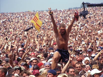 Un hombre se alza sobre la multitud que atestó el festival Woodstock, en Rome (Nueva York) en julio de 1999.