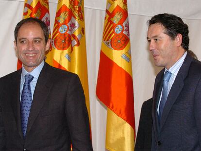 El ex ministro de Justicia, José María Michavila, y el presidente de la Comunidad Valenciana, Francisco Camps, posan junto a varias banderas españolas durante la recepción oficial en el Congreso.