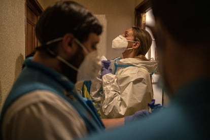 El equipo se prepara en el pasillo antes de acceder a una vivienda y atender a una paciente que presenta síntomas que podrían ser compatibles con la covid.