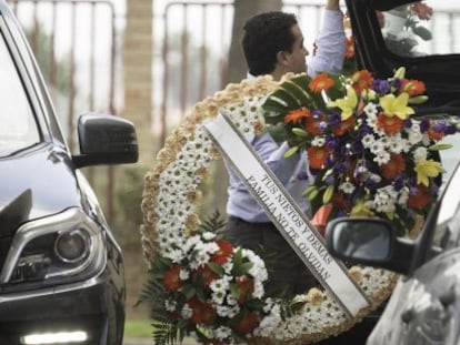 Un trabajador traslada una corona de flores de familiares de Ruiz-Mateos al velatorio organizado en una residencia de ancianos de El Puerto.