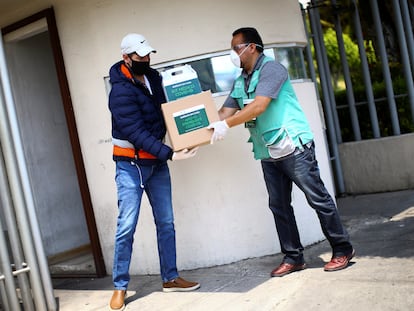 Un trabajador del Gobierno de Ciudad de México entrega un kit médico a un enfermo de covid, en abril de 2020.