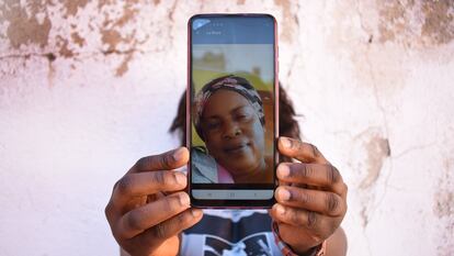 Glad oculta su rostro tras una fotografía de su madre, a quien envía dinero para subsistir en el Congo.