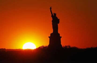 El sol se oculta detrás de la Estatua de la Libertad en Nueva York, 26 de mayo de 2013.