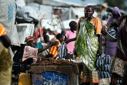 Una mujer compra pescado seco en un mercado establecido en el centro de protección de civiles (PoC) en Malakal, Sudán del Sur.