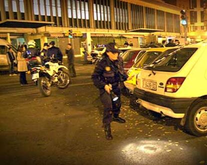 La policía, anoche, en el momento de registrar la zona del tiroteo en busca de casquillos de bala.