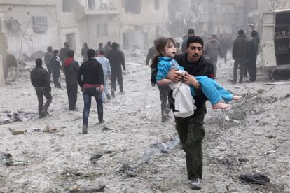 Alepo, Siria, 3 de febrero de 2013. Un hombre lleva una niña en brazos en Alepo, Siria, después de que un bombardeo destruyera una casa y matara a varias personas. La Batalla de Alepo es un enfrentamiento entre los rebeldes del Ejército Libre de Siria (ELS) y las Fuerzas Armadas de Siria. Los sublevados lanzaron una ofensiva a finales de 2012 y principios de 2013 para tomar el aeropuerto internacional de Alepo. Los rebeldes también atacaron la cercana base "Brigada Militar 80", que tomaron el 13 de febrero.