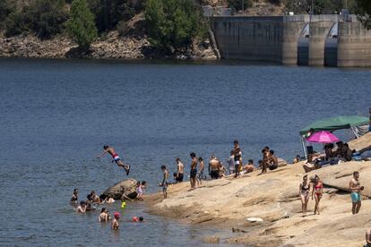 Un grupo de bañistas en la playa del Embalse de San Juan, en la sierra madrileña, en la tarde de este sábado. 