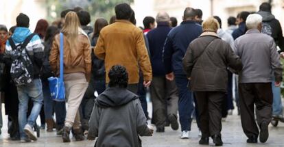 Un hombre pide limosna de rodillas en una calle de Valencia.