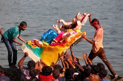 Devotos sumergen una estatua del Dios Elefante Ganesh en el ro Sabarmati , en Ahmedabad (India).