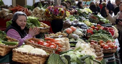 Una mujer al frente de su puesto de frutas y verduras en el centro de San Sebastián