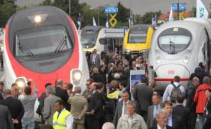 Varios visitantes observan trenes expuestos en un recinto de la feria InnoTrans. EFE/Archivo