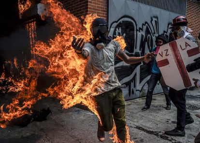 Un hombre corre en llamas después de que el tanque de combustible de la moto de un policía explotase durante una protesta en Caracas, el 3 de mayo de 2017.