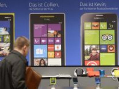 Un visitante de Cebit observa smartphones con Windows Phone.