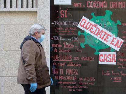 Un hombre pasa por un escaparate con el mensaje 