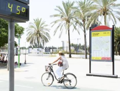 Una turista en bici por Sevilla en la primera semana de agosto.