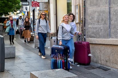 Turistas con maletas por la calle Carretas de Madrid.