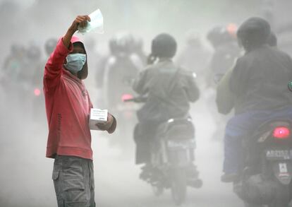 Un vendedor ofrece máscaras protectoras de la ceniza hoy, viernes 5 de noviembre de 2010, después de que las nubes de gas caliente, producto de la erupción del volcán Merapi, llegaran a las calles de Yogyakarta (Indonesia).