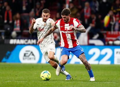 Rodrigo de Paul ante Dani Rodríguez, en el partido del Atlético ante el Mallorca en el Wanda Metropolitano.