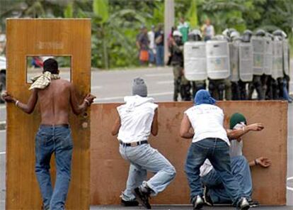 Estudiantes de la Universidad de Panamá lanzan piedras durante un enfrentamiento con la policía.