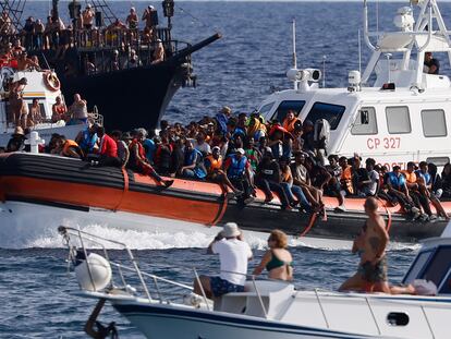 Un barco con migrantes rodeado de yates con turistas, este lunes en Lampedusa.