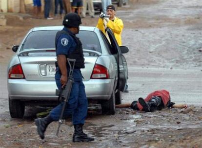 Dos agentes inspeccionan el lugar en el que fue asesinado un policía en el Estado de Sinaloa el miércoles.