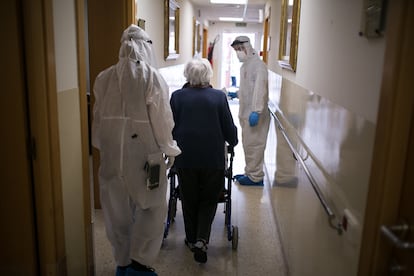 Voluntarios una ONG ayudan durante el traslado de ancianos a una residencia sin casos de coronavirus en Barcelona.
