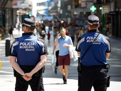 Dos polic&iacute;as municipales vigilan la calle de Preciados.