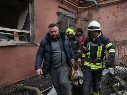 Efectivos de los servicios de emergencia transportan a una mujer herida en un bombardeo en un edificio residencial en Járkov este domingo.