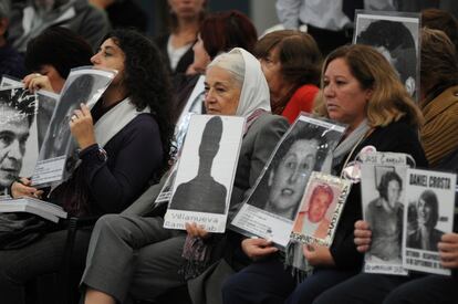 Manifestantes sostienen imágenes de personas desaparecidas durante la dictadura militar en Argentina