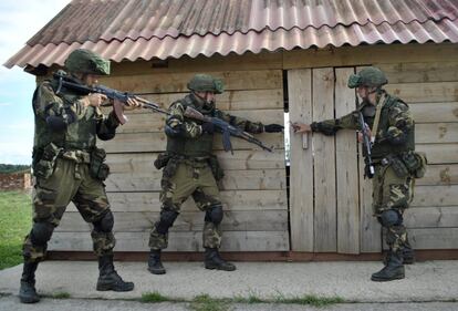 Tres soldados bielorrusos inspeccionan una cabaña, el 16 de septiembre.