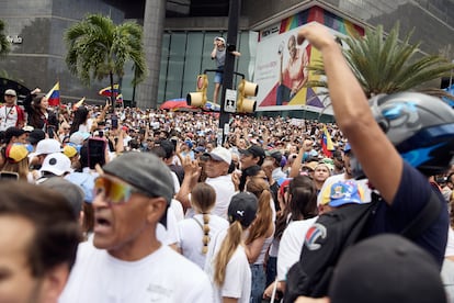 Una mujer parada en un semáforo grita "¡Libertad!" en un altavoz.