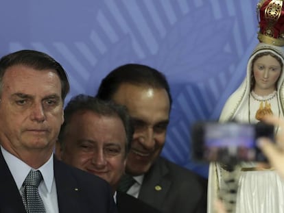 Bolsonaro posa para una foto con una imagen de la virgen de Fátima al fondo.