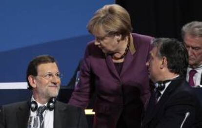 El presidente del Gobierno español,  Mariano Rajoy (i), conversa con la canciller alemana, Angela Merkel (c), durante el Congreso del Partido Popular Europeo, en Bucarest (Rumania). EFE/PP