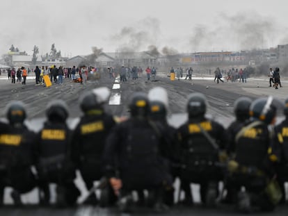 Varios policías observan a un grupo de manifestantes en el aeropuerto Alfredo Rodríguez Ballón, en Arequipa (Perú).