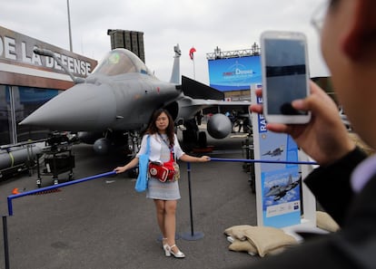 Una de las visitante se fotografía frente un caza militar, solo una de las muestras de la feria.