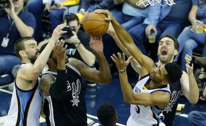 Marc y Pau Gasol luchan, entre otros, por un rebote.