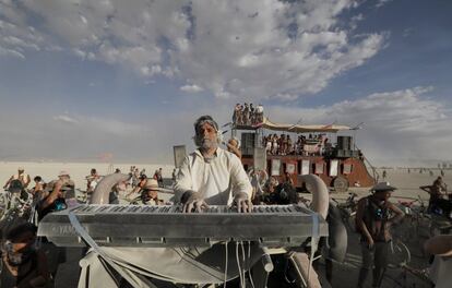 El pianista Murray Hidary toca una composición clásica con su piano electrónico en la parte superior de un coche a los participantes del Burning Man.