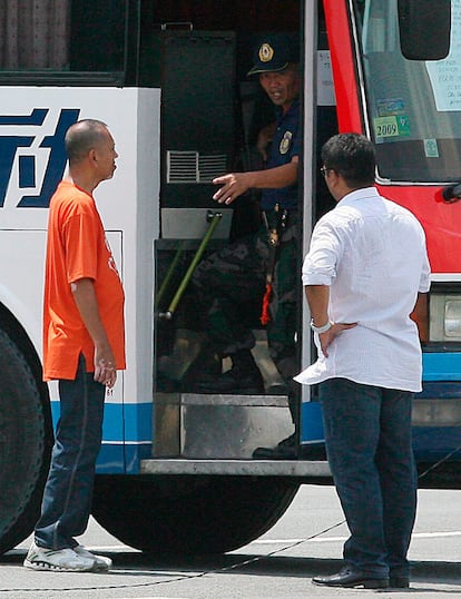 Dos negociadores de la Policía filipina conversan con el secuestrador del autobús en Manila (Filipinas). El ex agente Rolando del Rosario Mendoza, armado con un fusil de asalto M-16.