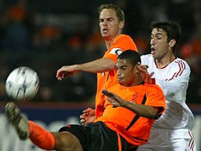 El defensa holandés Reiziger despeja el balón ante Raúl y su compañero De Boer.
