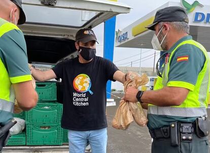 Un voluntario de World Central Kitchen reparte comida a dos agentes de la Guardia Civil en La Palma.