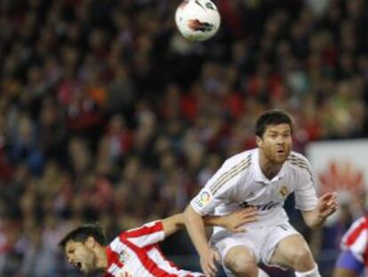 Xabi Alonsoa salta por el balón con el brasileño Diego