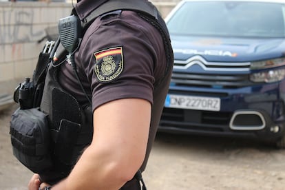 Un agente de la Policía Nacional junto a su vehículo.