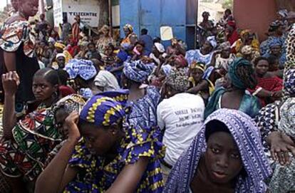 Decenas de mujeres senegalesas aguardan noticias de sus familiares frente a una base naval de Dakar.